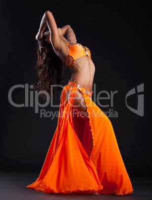 Expressive woman posing in orange arabic costume