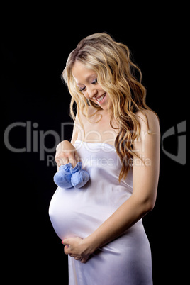 Yong pregnant woman play with baby's bootee