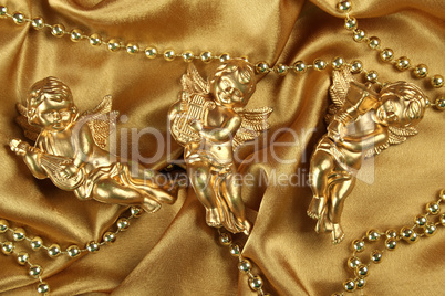 Three angels on a golden fabric