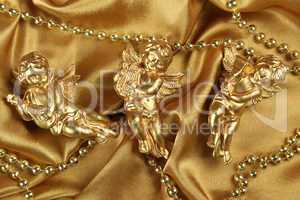 Three angels on a golden fabric