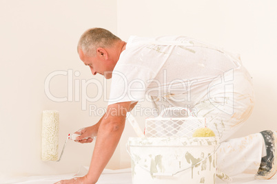 Home decorating mature man with paint roller