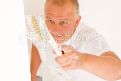 Home decorating mature man painting wall brush