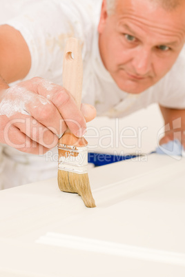 Home decorating mature man painting door brush
