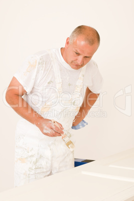 Home decorating mature man painting door brush