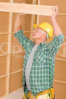 Handyman carpenter mature fitting wooden beam