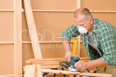 Handyman sanding wooden board diy home renovation