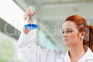 Scientist looking at a blue liquid