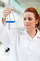 Portrait of a science student looking at a blue liquid