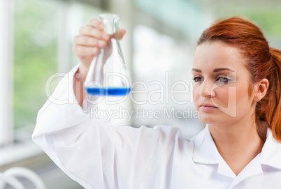 Science student looking at a blue liquid