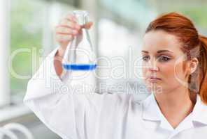 Science student looking at a blue liquid