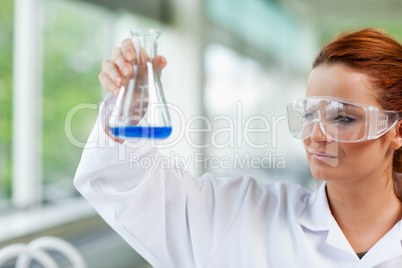 Science student looking at an Erlenmeyr flask