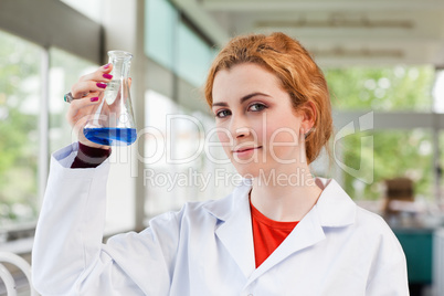 Chemist holding a blue liquid