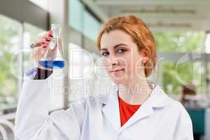 Chemist holding a blue liquid