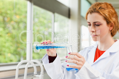 Red-haired scientist pouring liquid