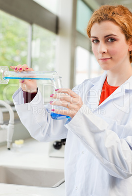 Portrait of a cute scientist pouring liquid