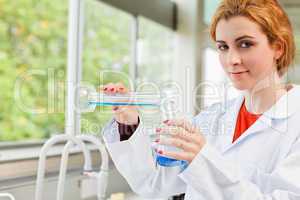 Cute scientist pouring liquid