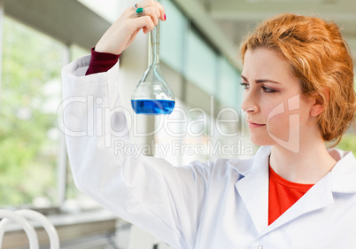 Cute scientist holding a blue liquid