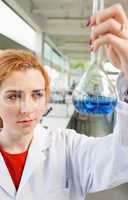 Portrait of a cute science student holding a blue liquid