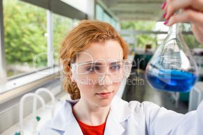 Science student looking at a flask