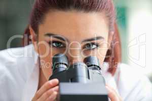 Close up of a scientist posing with a microscope