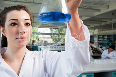Science student looking at a blue liquid