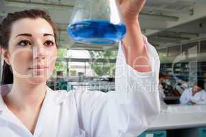 Science student looking at a blue liquid