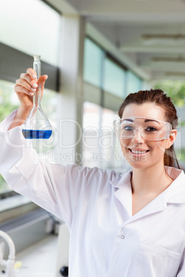 Portrait of a female science student holding a blue liquid