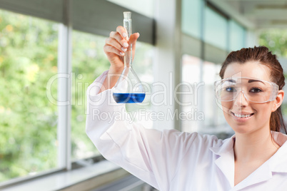 Female science student holding a blue liquid