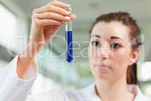 Brunette scientist looking at a test tube