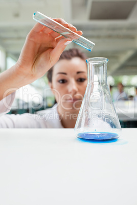 Portrait of a serious science student pouring liquid