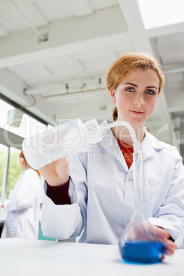 Portrait of a gorgeous scientist pouring liquid