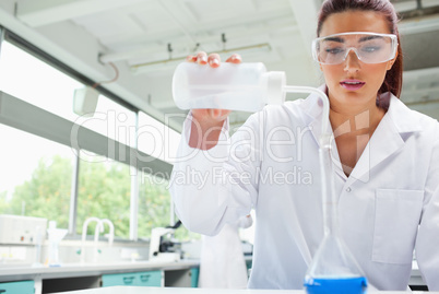 Female science student pouring liquid