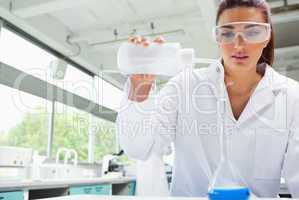 Female science student pouring liquid