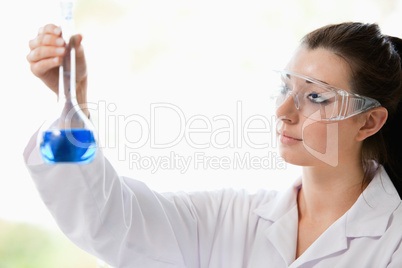 Beautiful scientist looking at a flask