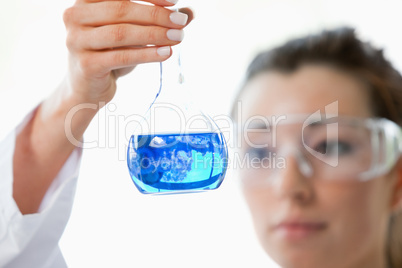 Close up of beautiful scientist looking at a flask