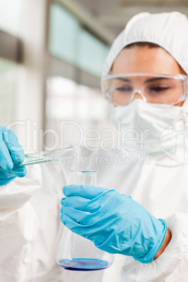 Portrait of a protected scientist pouring liquid