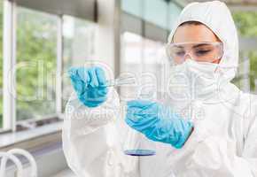 Protected scientist pouring liquid
