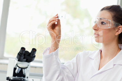 Beautiful science student looking at a microscope slide