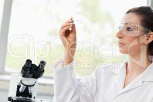 Beautiful science student looking at a microscope slide