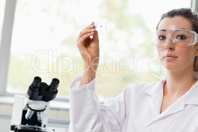 Beautiful science student holding a microscope slide