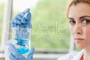 Scientist dropping liquid in a beaker