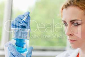 Cute scientist dropping liquid in a beaker