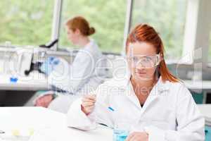 Science student dropping blue liquid in a beaker