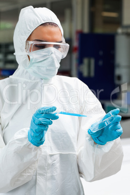 Portrait of a protected science student dropping blue liquid in