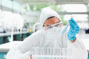 Protected scientist looking at a test tube
