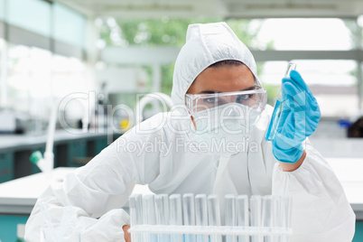 Protected female scientist holding a test tube