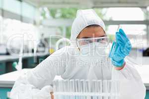 Protected female scientist holding a test tube