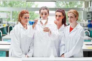 Science students pouring liquid in a flask