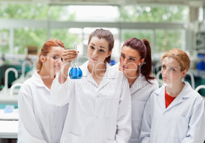 Cute science students looking at a flask