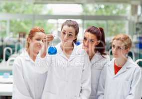 Cute science students looking at a flask